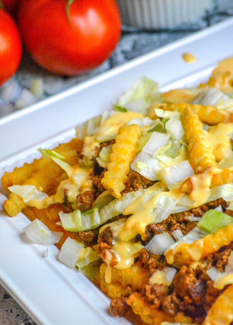 bacon cheeseburger french fries on a white serving platter