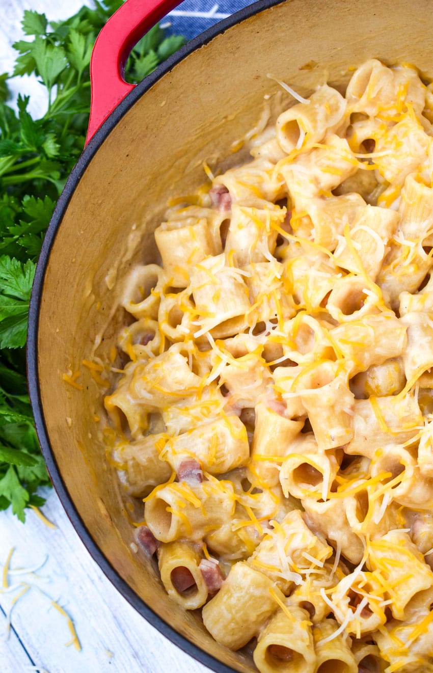 cheesy riggies pasta with ham in a large red dutch oven