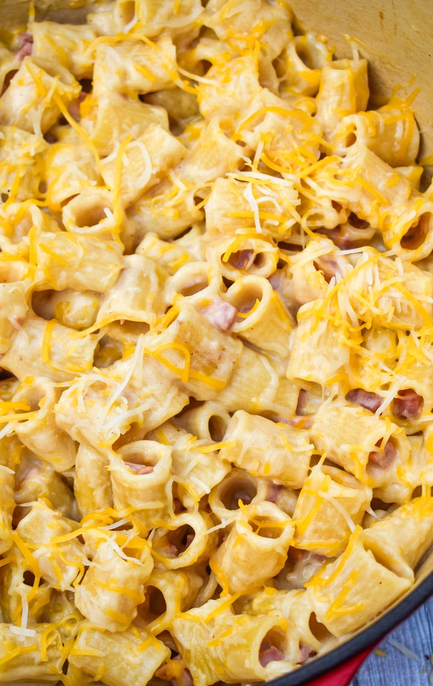 cheesy riggies pasta with ham in a large red dutch oven