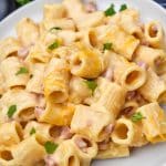 cheesy riggies pasta with ham on a white plate