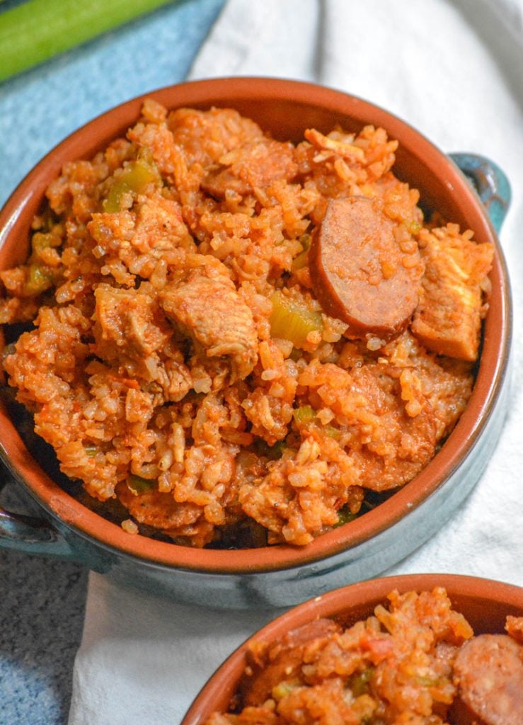 Dutch Oven Jambalaya with chicken and smoked sausage served in blue glazed terra cotta bowls