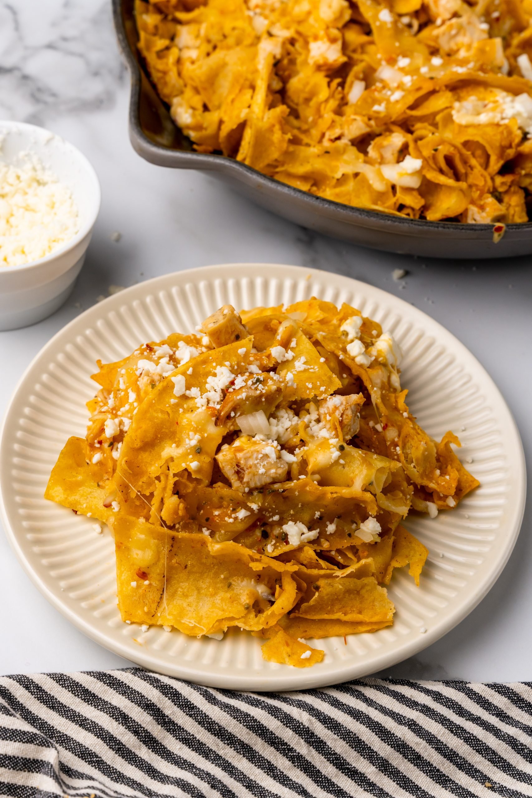 cheesy chicken chilaquiles on a small white plate