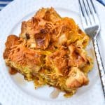 a slice of chicken and waffles casserole on a small white plate with a silver fork resting on the edge