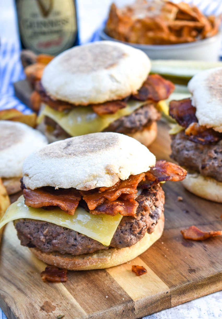 guinness burger with bacon and irish cheddar on a wooden cutting board