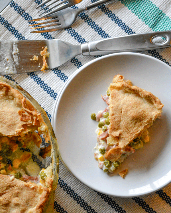 a slice of ham and vegetable cobbler on a white plate