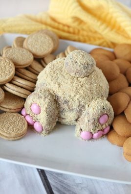 Easter bunny butt cheese ball on a white platter surrounded by cookies