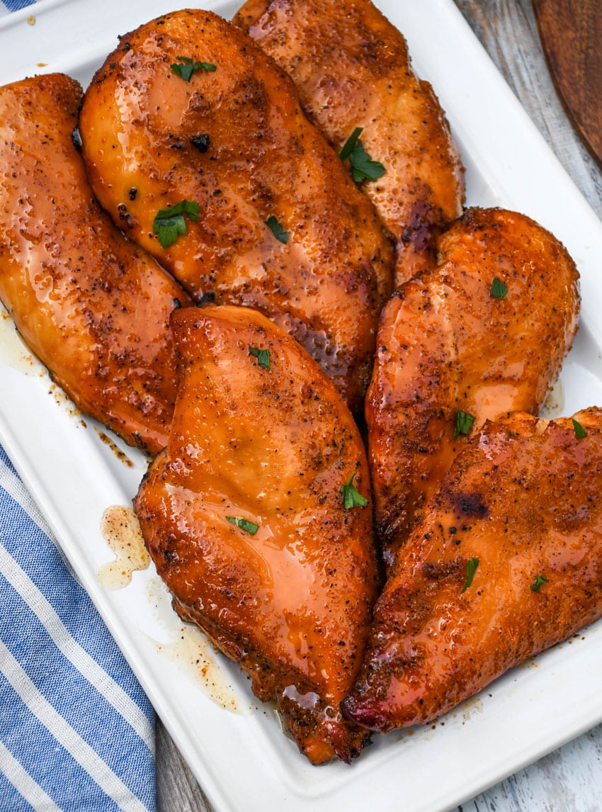 smoked cajun honey chicken breasts on a white serving platter