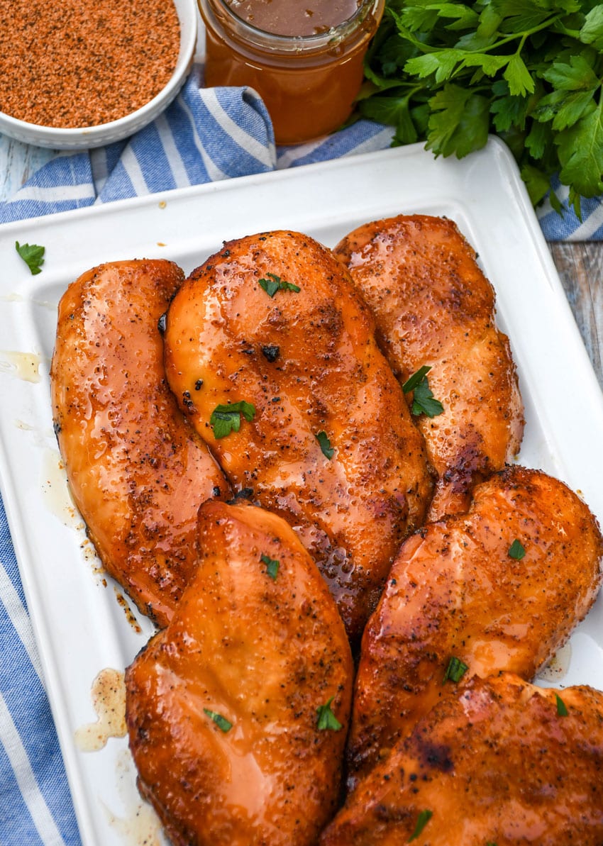 smoked cajun honey chicken breasts on a white serving platter