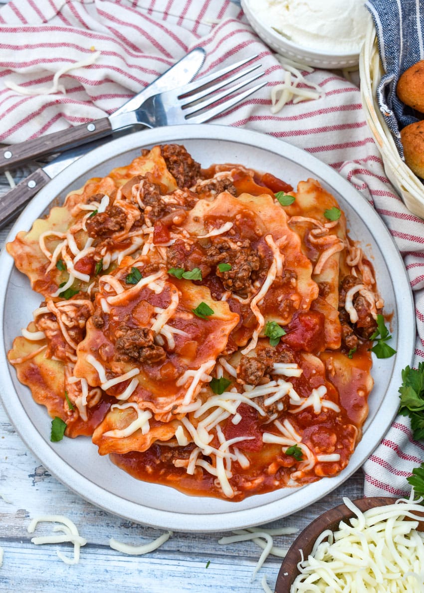 RAVIOLI SKILLET LASAGNA ON A WHITE PLATE WITH A FORK RESTING ON THE SIDE