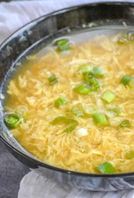 A BOWL OF EGG DROP SOUP ON A WOODEN TABLE