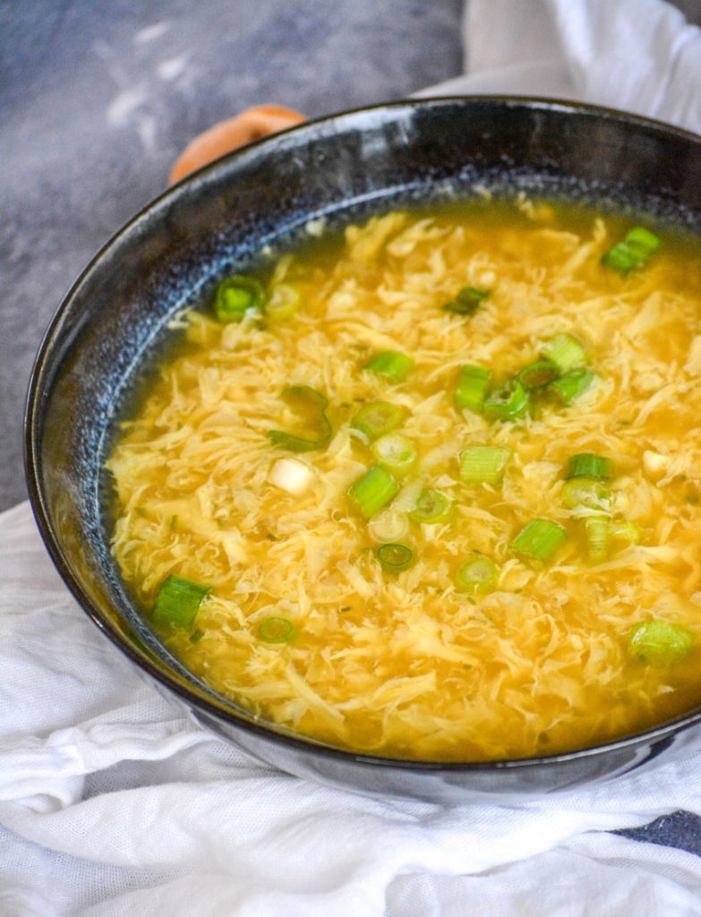 creamy egg wisps floating in golden brown chicken broth are topped with tangy green onions in this authentic egg drop soup