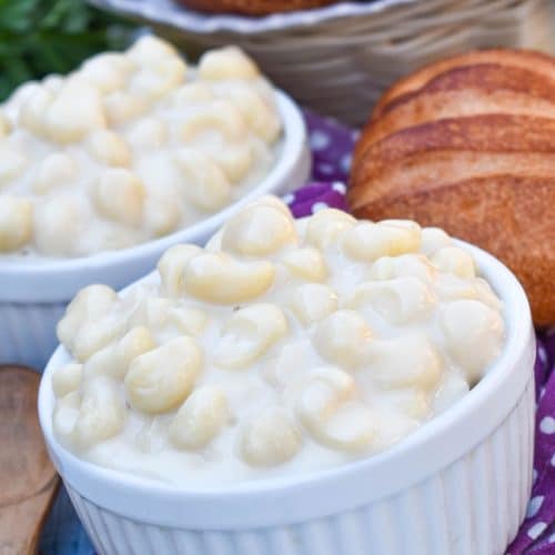 copycat panera mac and cheese recipe shown in two white ramekins with crusty rolls on the side