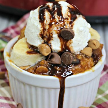 A SCOOP OF SLOW COOKER ELVIS PUDDING CAKE IN A SMALL WHITE RAMEKIN WITH CHOCOLATE SAUCE DRIZZLED OVERTOP