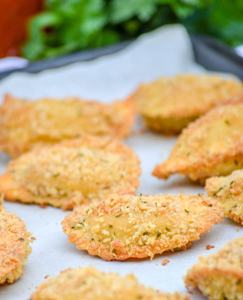 crispy baked ravioli shown on a parchment covered baking sheet