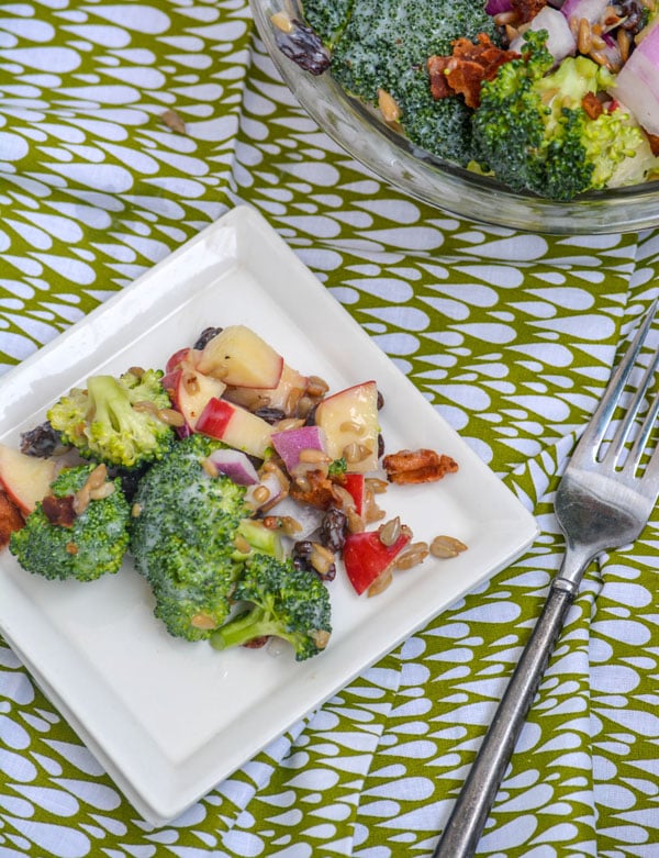 a creamy broccoli salad with bits of crisp bacon, tangy red onion, sweet apples, & crunchy sunflower kernels