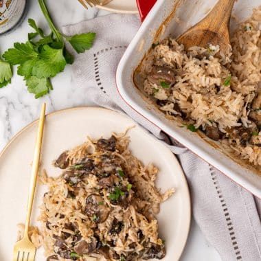 chicken marsala and rice casserole served on white plates with a golden fork on the side