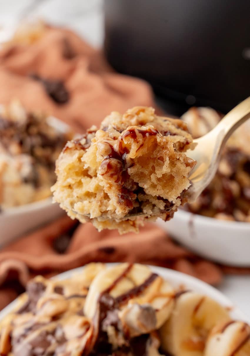 a gold spoon holding up a scoop of slow cooker peanut butter banana cake