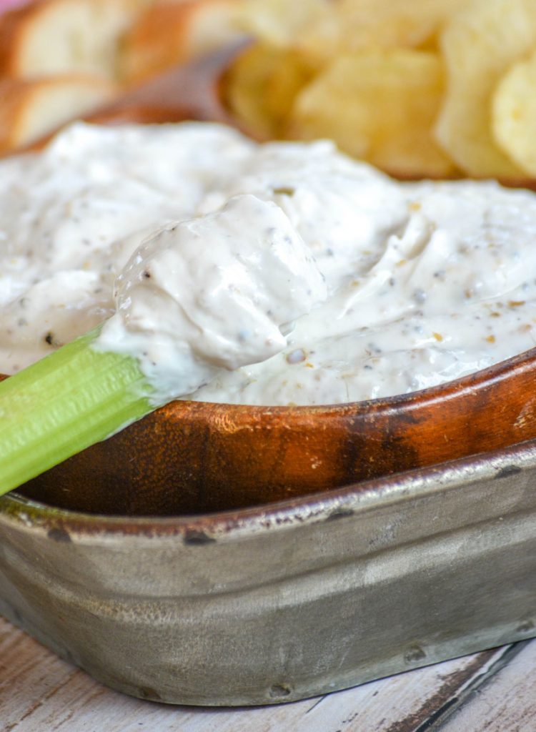 Montreal Steak Seasoning Dip served in a teak bowl with chips and veggies for dipping