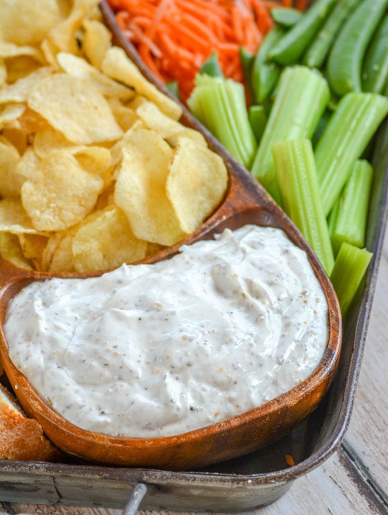 Montreal Steak Seasoning Dip served in a teak bowl with chips and veggies for dipping