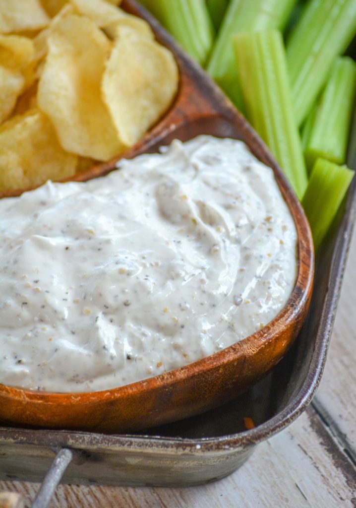 Montreal Steak Seasoning Dip served in a teak bowl with chips and veggies for dipping