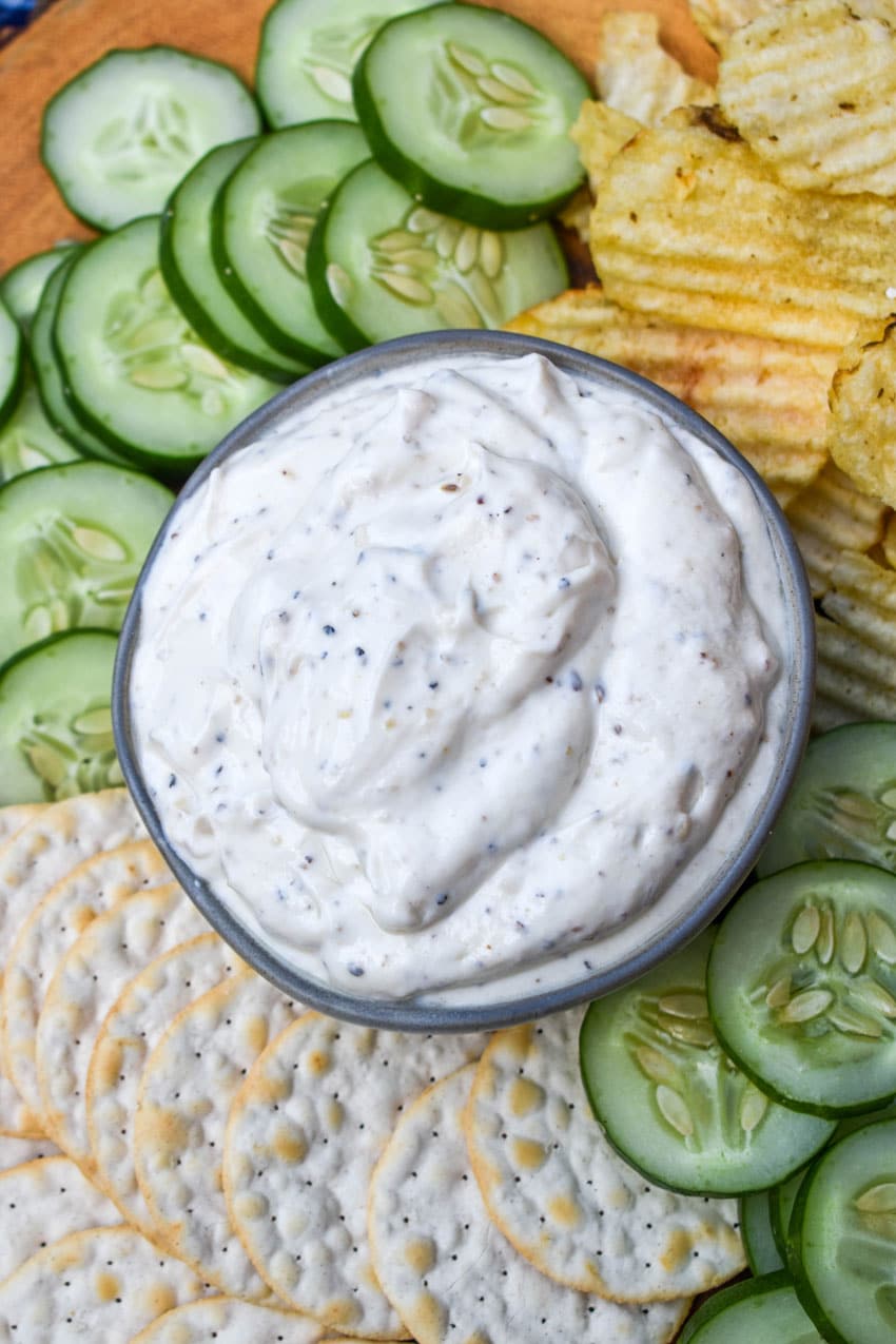 montreal steak seasoning dip in a small gray bowl surrounded by chips and crackers