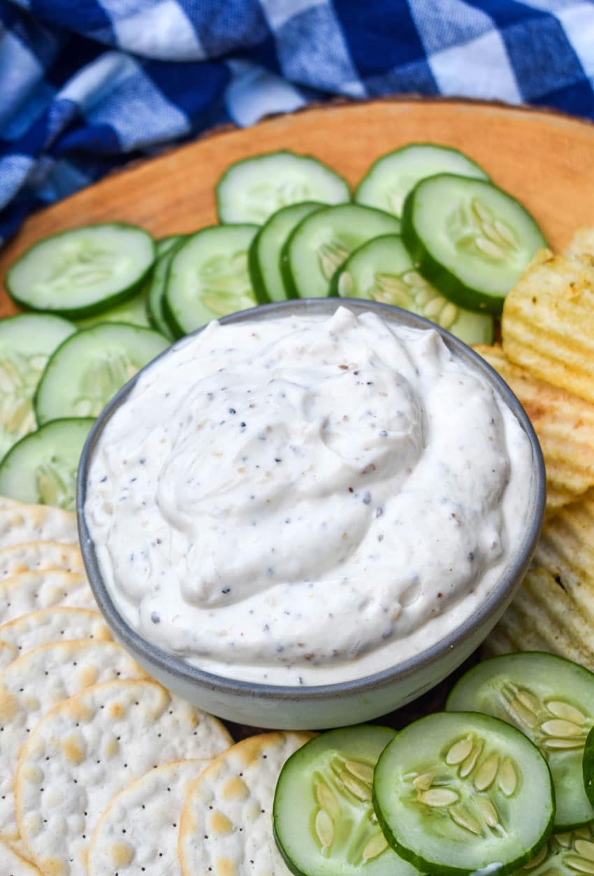 montreal steak seasoning dip in a small gray bowl surrounded by chips and crackers