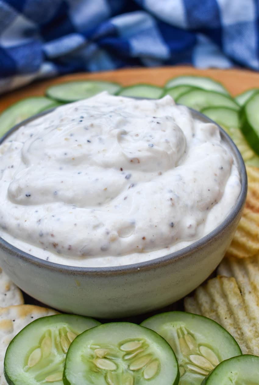 montreal steak seasoning dip in a small gray bowl surrounded by chips and crackers