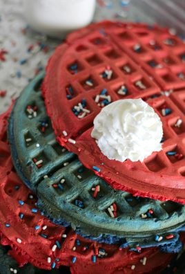 a dollop of whipped cream on red white and blue stacked waffles