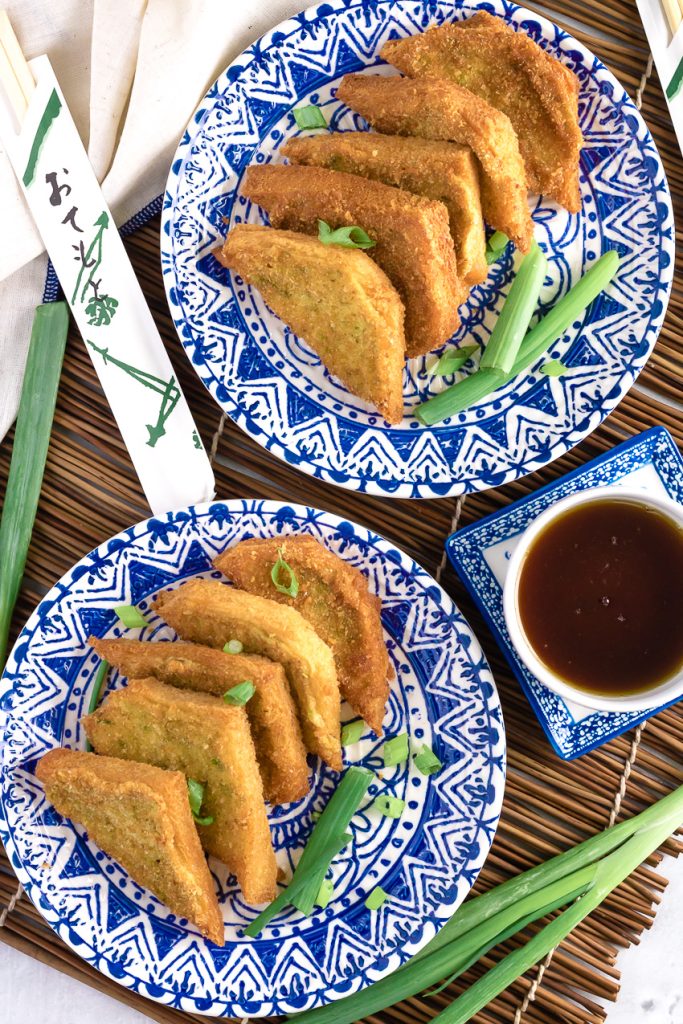 Shrimp Toast Recipe layered on two blue and white oriental style plate on a bamboo cutting board