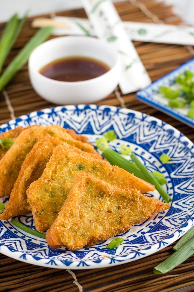 Shrimp Toast Recipe layered on a blue and white oriental style plate on a bamboo cutting board