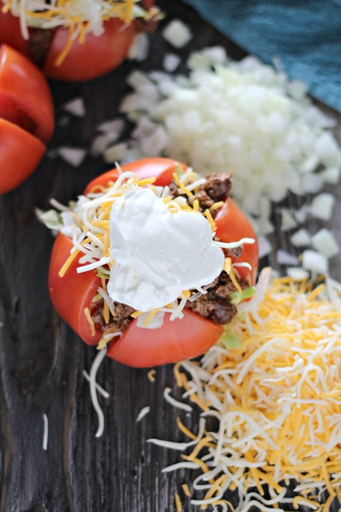 taco stuffed tomatoes topped with shredded mexican blend cheese & sour cream