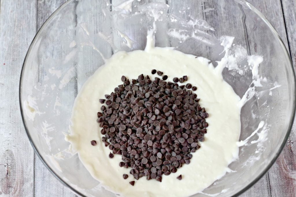 the beginnings of cannoli dip show a sweet cream with chocolate chips ready to be mixed in