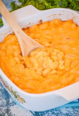 a wooden spoon scooping copycat stouffers mac and cheese out of a small white pyrex dish