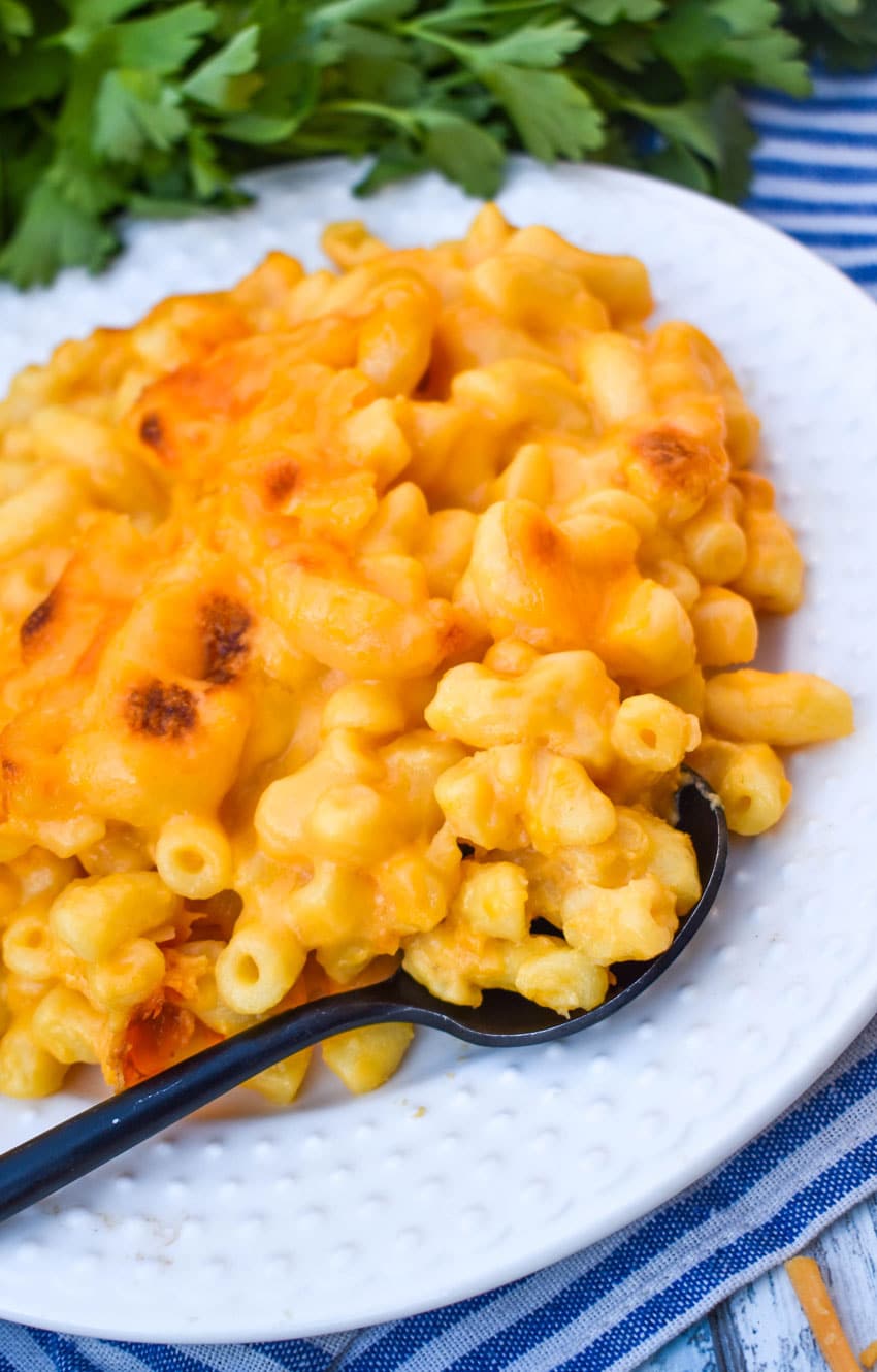 homemade stouffer's mac and cheese on a white dinner plate with a black spoon resting on the side