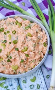 buffalo ranch chicken salad in a large gray serving bowl surrounded by green onions
