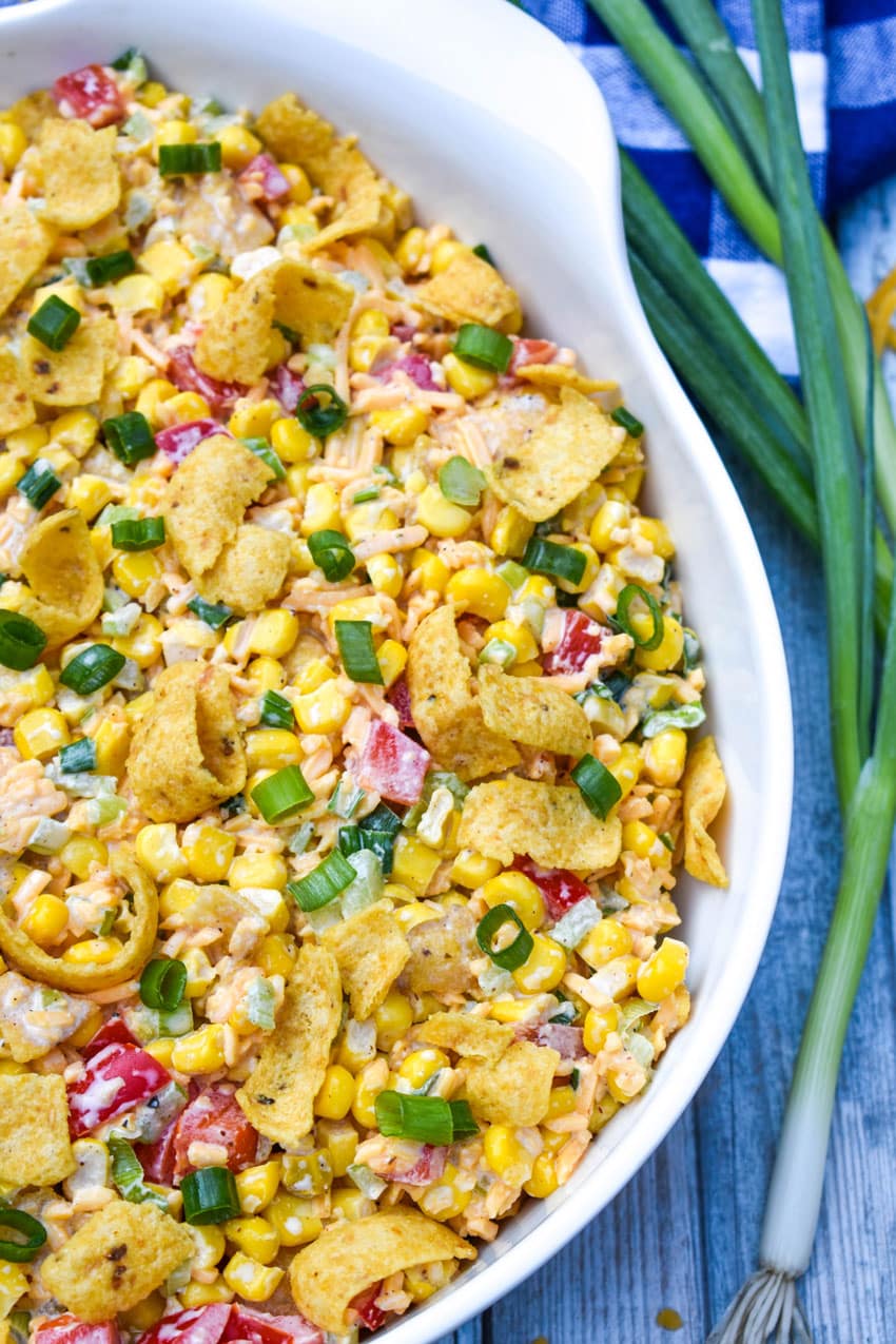 crunchy corn salad with fritos in a large white serving bowl with green onions on the side