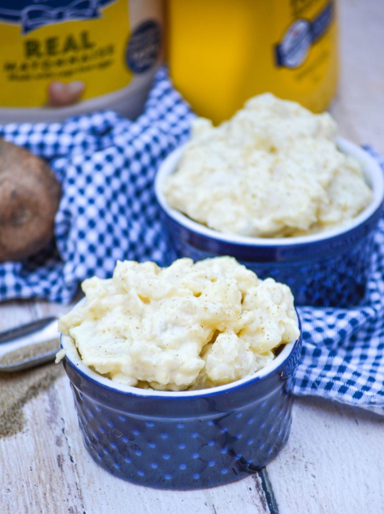 Grandma's Simple Southern Potato Salad with mayonnaise & yellow mustard in the background in blue ramekins on a checkered napkin on top of a picnic table