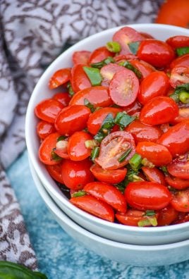 MARINATED TOMATO SALAD TOPPED WITH FRESH HERBS IN A WHITE BOWL