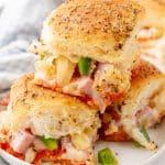 hawaiian pizza sliders stacked on a small white plate