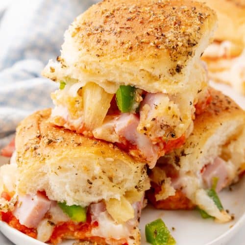 hawaiian pizza sliders stacked on a small white plate