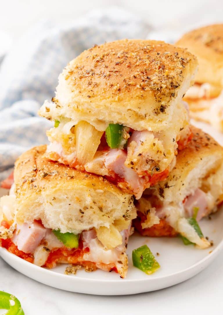 hawaiian pizza sliders stacked on a small white plate