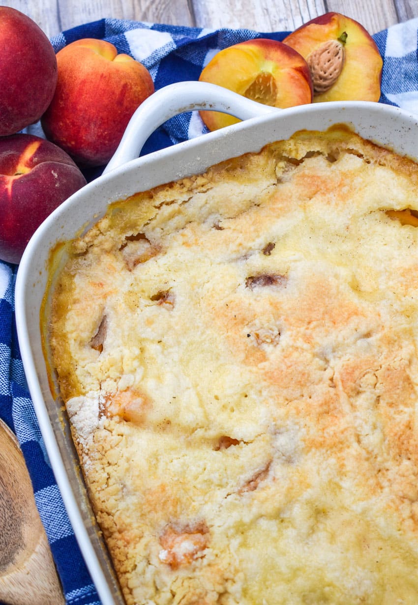 peach cobbler dump cake in a white baking dish