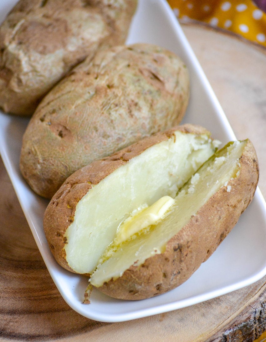 10 MINUTE MICROWAVE BAKED POTATOES ON A WHITE SERVING PLATTER