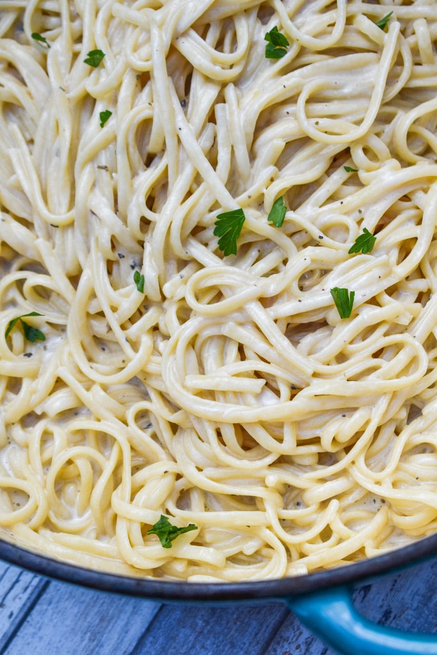 creamy garlic parmesan pasta in a large blue dutch oven