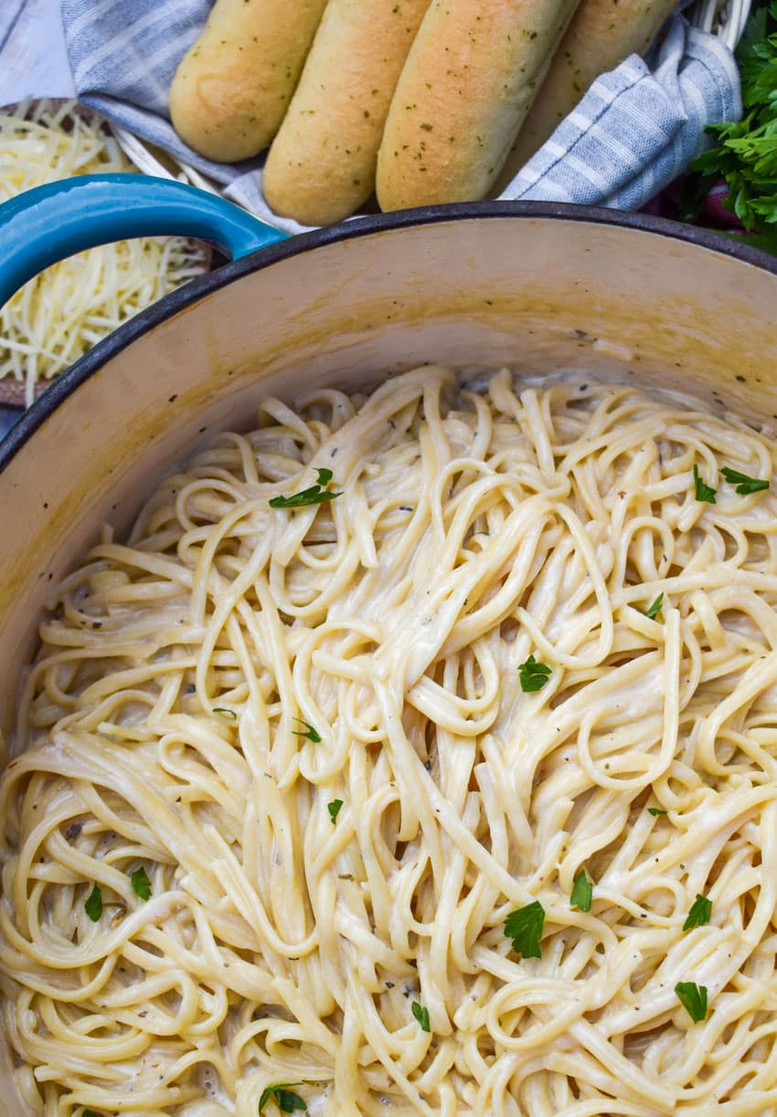 creamy garlic parmesan pasta in a large blue dutch oven
