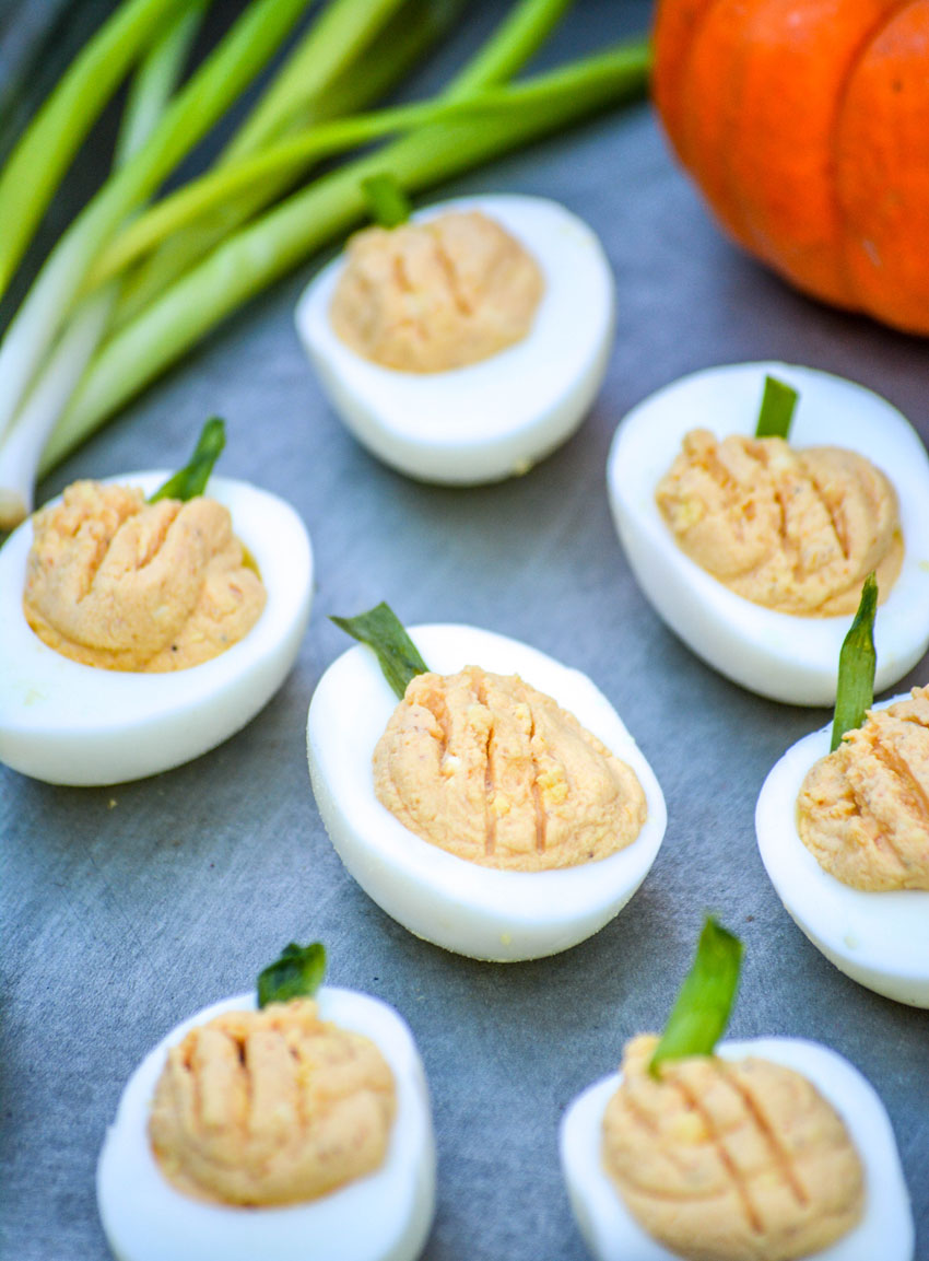 pumpkin deviled eggs on a galvanized metal tray