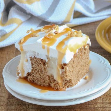 A SLICE OF APPLE SPICE POKE CAKE ON A SMALL WHITE PLATE