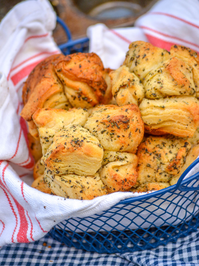 GARLIC HERB PULL APART ROLLS IN A CLOTH LINED BLUE WIRE BASKET