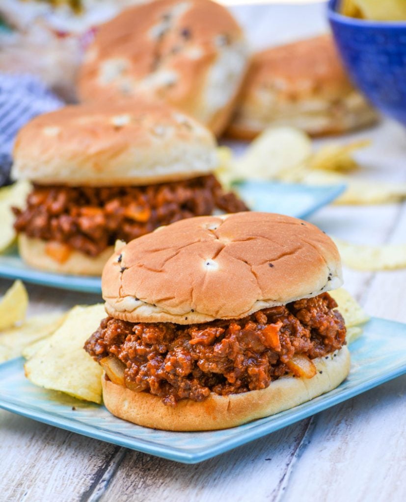 Grandma's sloppy joe's from scratch served on light blue plates with potato chips