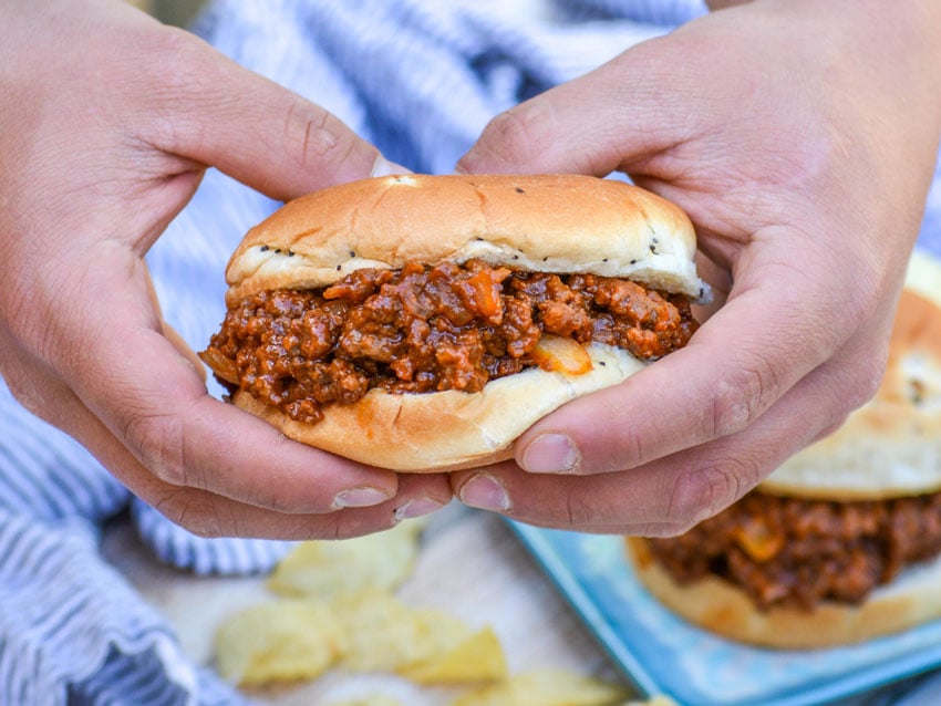 hands holding up one of Grandma's from scratch sloppy joe sandwiches